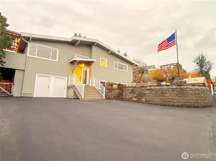 The front porch roof is new, new door, the side and upper window above was rebuilt plus resided, the entire house has been repainted. The original 1 car garage has been transformed into a workshop/ storage area (left door) and a private entry door leading to the lower-level living area (right door) Can easily be returned to a 1 car garage