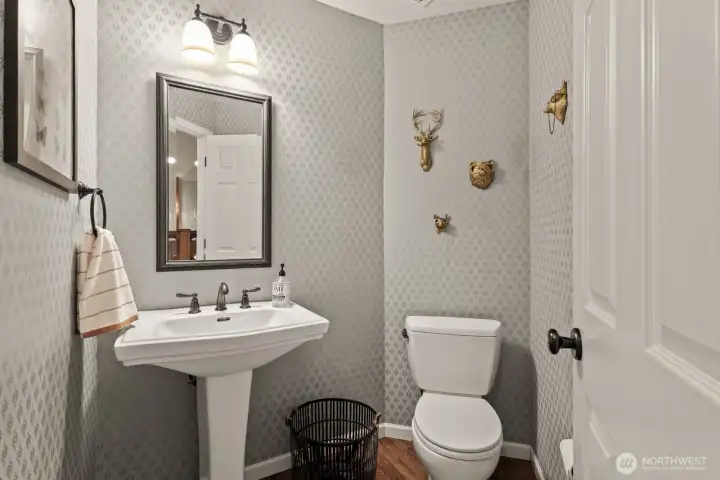 Designer wallpaper adds a touch of elegance and elevates the style of this powder room.
