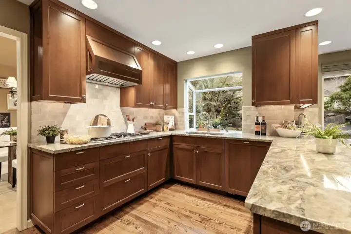 The kitchen is a true showpiece, thoughtfully designed with custom-crafted cherry cabinets, slab granite countertops.
