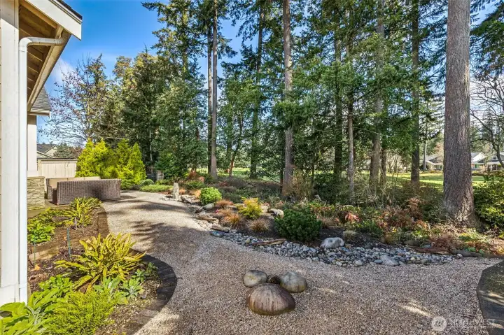 Professionally landscaped yard with granite bubbler fountain creates a serene canvas for your outdoor activities