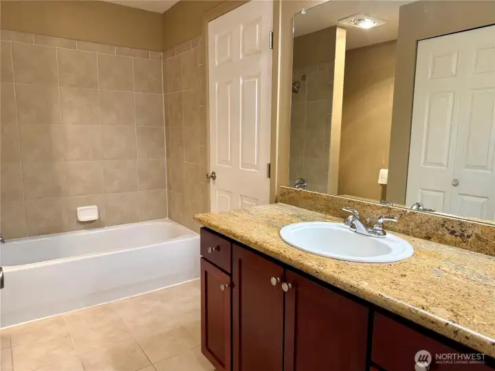 Upstairs Full Bath with tiled shower and access to Primary Bedroom