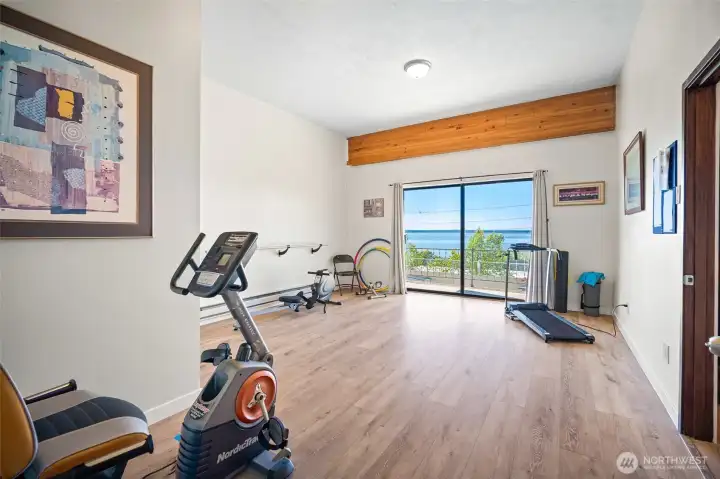 Fitness room, updated with view towards the Bay.  Outdoor slider to balcony.  Separate bathroom to the left and the dry sauna to the right.