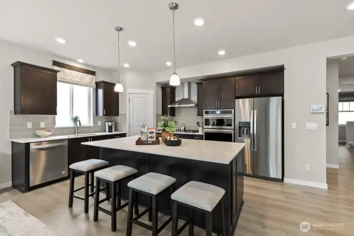 HUGE kitchen island with hard surface counter tops. Photo rendering is representational and may be virtually staged. Actual home is under construction and finishes, elevation, and paint colors may vary. See site agent for details.