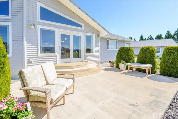 Patio outside main living area, framed by mature landscaping. Patio outside main living area, framed by mature landscaping.