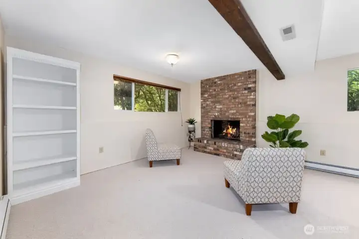 A beautiful and spacious family room that embodies a great room concept with striking espresso beams above and original brick wood burning fireplace that comforts. Outside, mature landscaping provides privacy and filtered light.