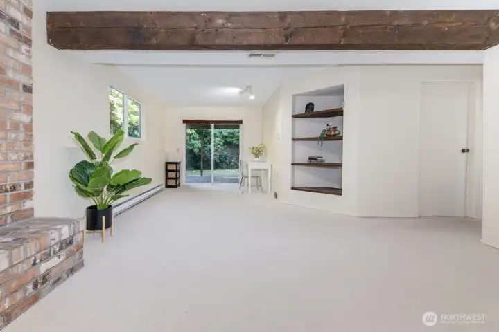 A beautiful and spacious family room that embodies a great room concept with striking espresso beams above and original brick wood burning fireplace that comforts. Outside, mature landscaping provides privacy and filtered light.