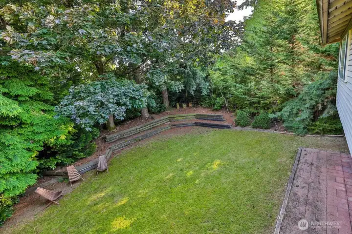 Surrounded by mature evergreen landscaping, cherry trees, and grape vines, the home's highlight is a beautiful, private backyard complete with a cedar deck, brick patio and line of statuesque trees providing total privacy.
