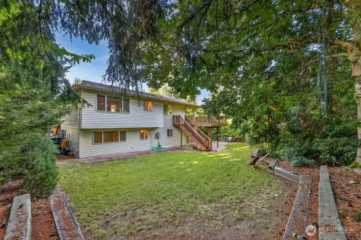 Surrounded by mature evergreen landscaping, cherry trees, and grape vines, the home's highlight is a beautiful, private backyard complete with a cedar deck, brick patio and line of statuesque trees providing total privacy.