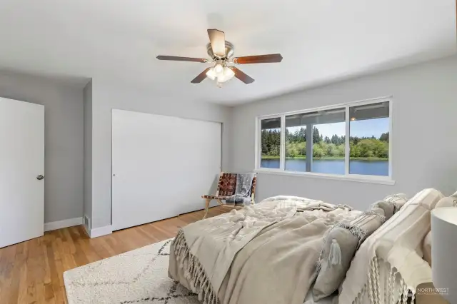 On the main floor, the spacious second bedroom enjoys a large closet, hardwood floors, and looks out onto the lake.