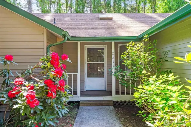 Landscaped lined pathway leads to covered front entrance.