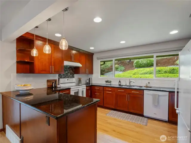 Hardwood flooring, granite slab countertops, and cherry cabinets with crown molding.