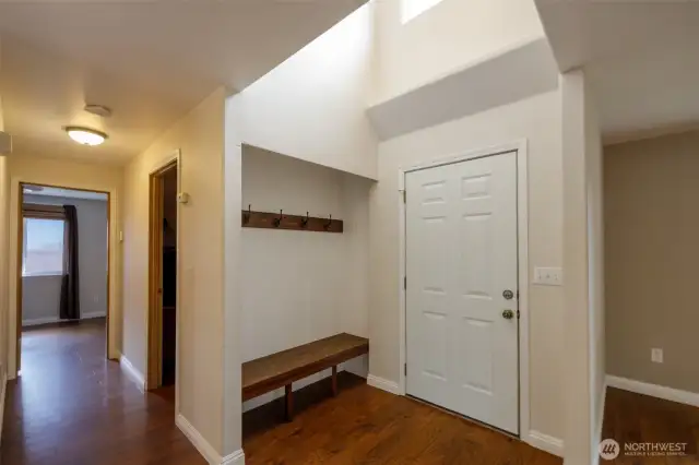The main level features natural wood flooring, as well as a built-in bench and coat rack in the foyer.
