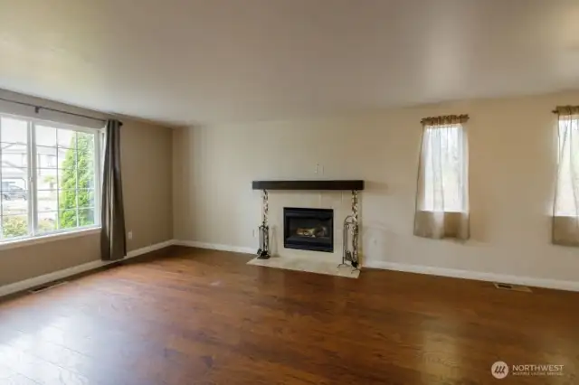A large combined living/dining area showcases a cozy tiled gas fireplace