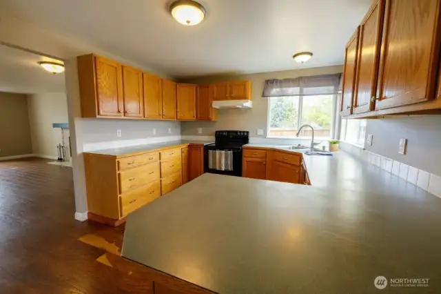 The kitchen provides ample counter space and storage with a corner window above the sink, all appliances included.