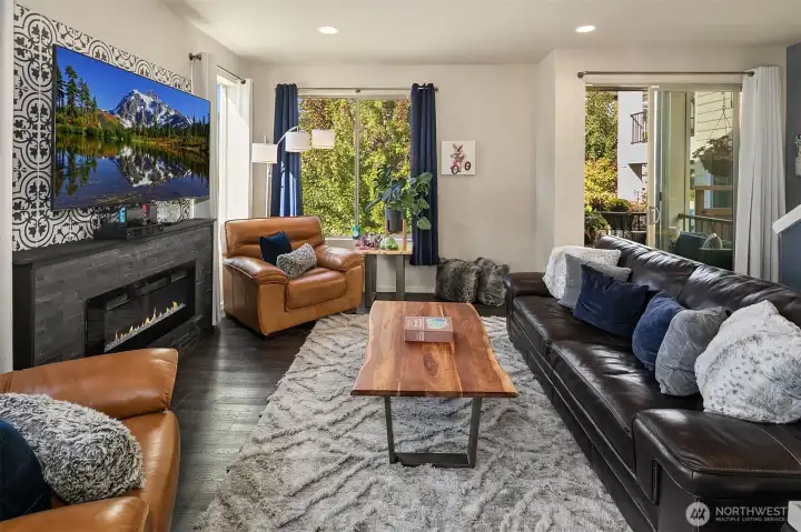 Large living area with a showstopping electric fireplace as a focal point. The custom wood and tile surround is simply fantastic.