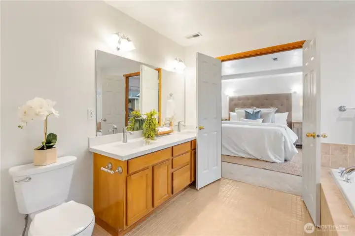 The primary bathroom features updated dual quartz vanity sinks and a new toilet.