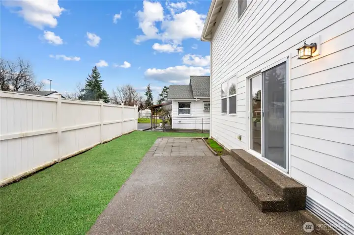 Backyard with digitally enhanced grass to show the potential of this backyard or keep as-is for a low-maintenance outdoor space.