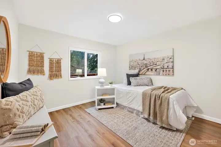 Cozy bedroom with LVP flooring, a sliding window, and a light, neutral finish — versatile enough for a guest room, office, or additional sleeping space.