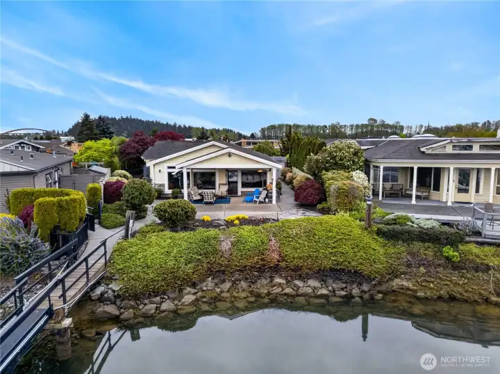 Beautiful waterfront retreat with lush landscaping, expansive patio space, and direct access to calm shoreline living.