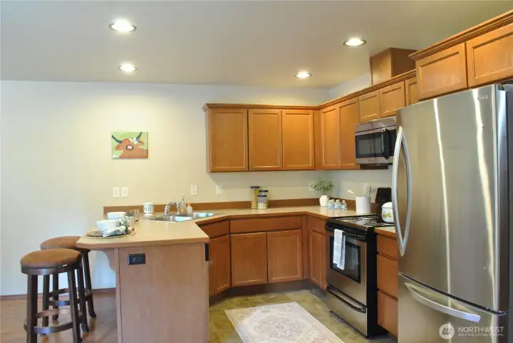 Functional kitchen offering extensive cabinet storage, durable countertops, stainless steel appliances, and excellent workspace.