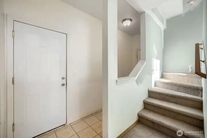 Main level entrance with garage entrance, large storage closets, and stairs to upper levels.
