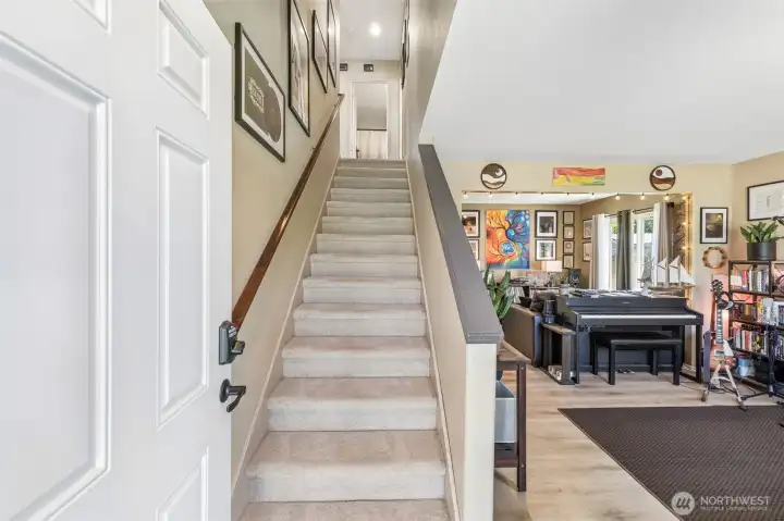 Light-filled entry and front living room with staircase to the upper level, creating an open and inviting first impression. Light-filled entry and front living room with staircase to the upper level, creating an open and inviting first impression.