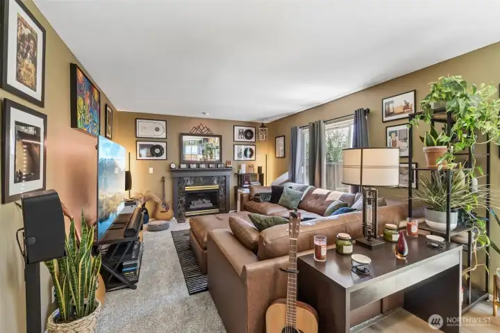 Seamless connection between living room, kitchen, and dining area with a warm gas fireplace as the focal point. Seamless connection between living room, kitchen, and dining area with a warm gas fireplace as the focal point.