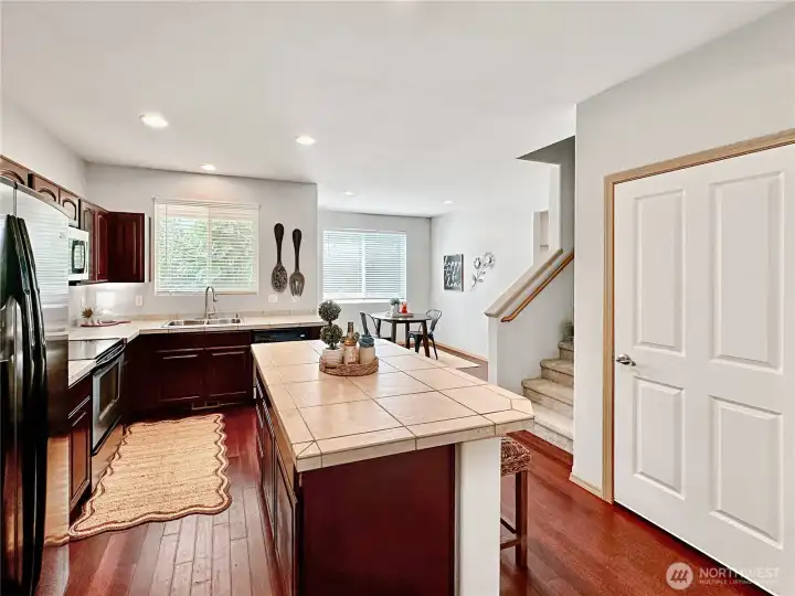 Lovely kitchen with engineered wood floors, tile counters, stainless appliances, eating counter and loads of cabinets. Lovely kitchen with engineered wood floors, tile counters, stainless appliances, eating counter and loads of cabinets.