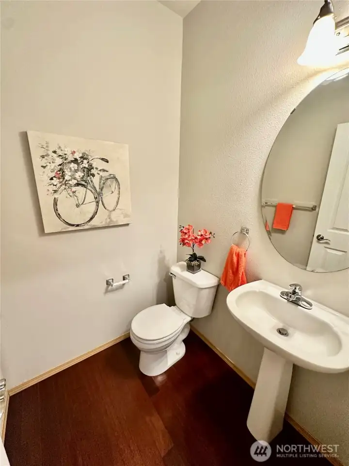 Main floor powder room with engineered floor and pedestal sink. Main floor powder room with engineered floor and pedestal sink.
