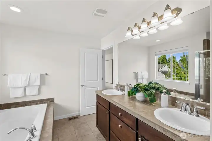 The primary bathroom en-suite features a large vanity with plenty of storage and dual sinks