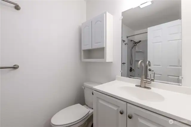 Hall full bath with single vanity, storage cabinet, and Lutron Maestro (motion sensing switch)