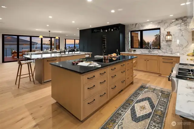 Kitchen showing panel ready refrigeration with wine column in black. Also access to speakeasy through left side cabinets.