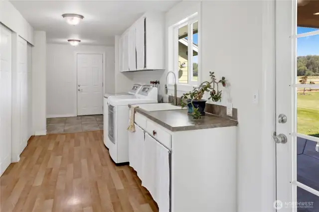 Large mudroom/ laundry room has access to the attached garage and the backyard