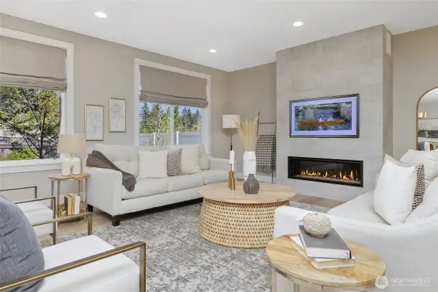 The large living room windows offer a serene view of the fenced backyard, where mature trees and greenery add visual interest.