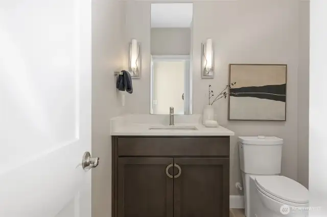 The powder room, just off the grand foyer, is enhanced by beautiful sconce lighting and a surprisingly spacious linen closet. Adding a modern touch throughout, all three bathrooms are equipped with hands-free flush toilets.