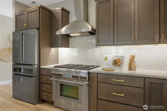 The glass surfaced Bosch refrigerator includes filtered water, an ice maker, and a beautiful double-layer wine drawer with custom temperature control. The 6-burner gas cooktop and gas oven combination is Thermador.