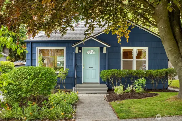 Welcome to this storybook Ballard bungalow, framed by lush greenery and the majestic canopy of a copper beech tree.