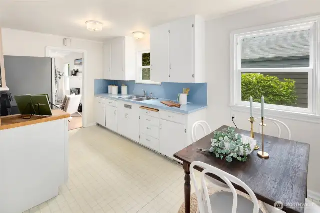 Crisp white cabinets, cheerful blue accents, and south-facing windows make the kitchen a feel-good space.