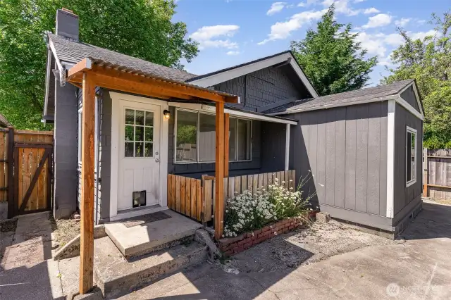 Cozy covered back porch features a convenient pet door and small fenced area that leads directly to the basement.