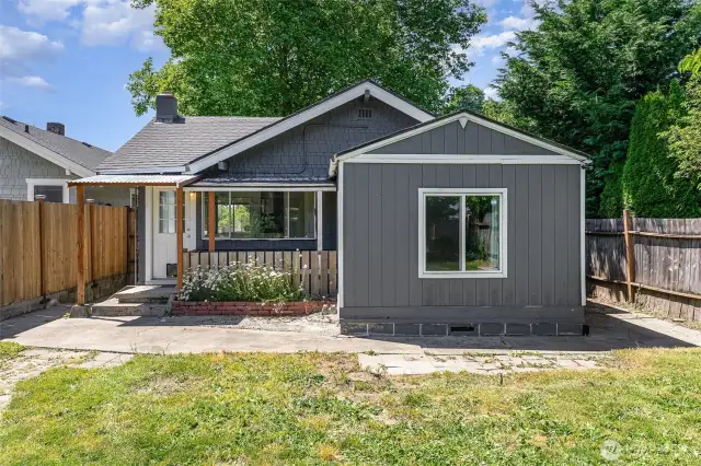 View of the home's exterior from the backyard showcases the charming architecture, mature landscaping, and inviting outdoor spaces.