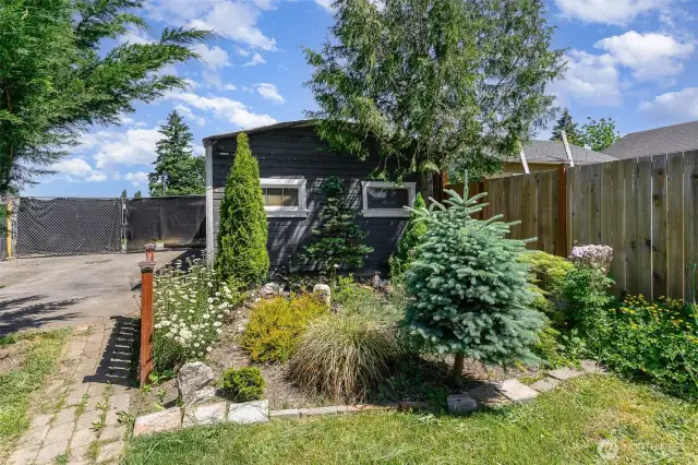 Beautiful mature landscaping enhances the property with lush greenery, creating a serene and inviting outdoor environment.