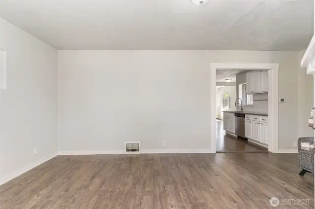 Enter into the spacious living room featuring warm-toned flooring and abundant natural light—perfect for relaxing or entertaining.