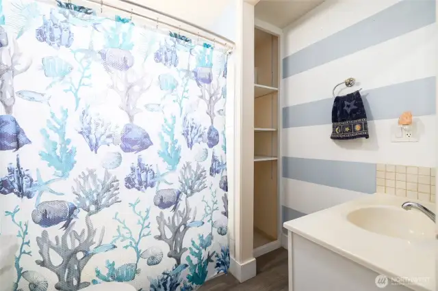 Tub shower combo on one end of hall.