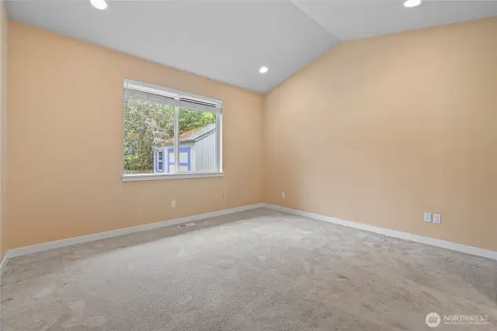 Primary bedroom with vaulted ceiling and tons of natural light