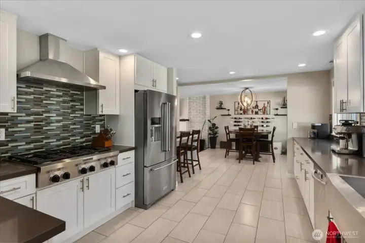 Fully remodeled kitchen, designed with quartz counters, soft-close white shaker cabinets, an apron-front stainless sink, and high-end KitchenAid appliances.  Breakfast bar overlooking the living room.