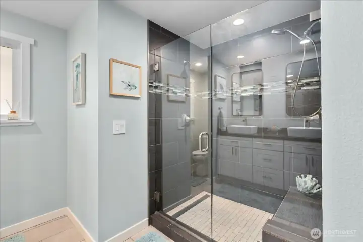 Main bath with a frameless glass shower, quartz counters, double sinks, and new mirrors.