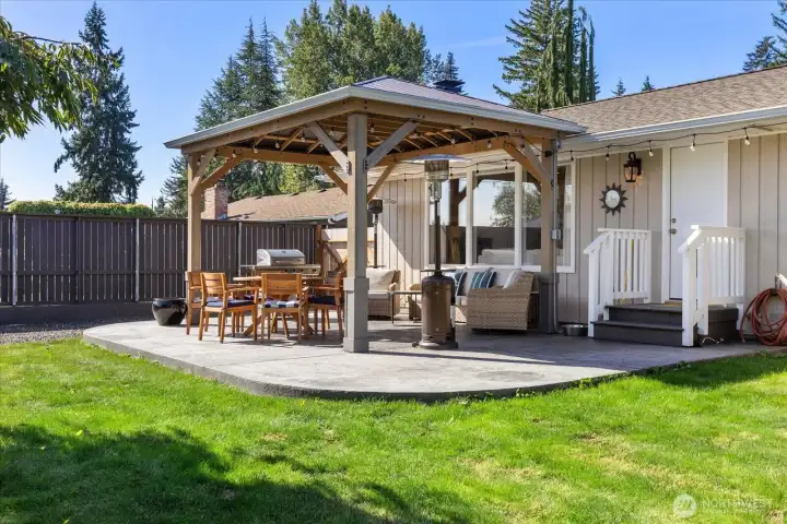 Stamped and stained concrete and a covered back patio with a gas stub for grilling under the large gazebo.