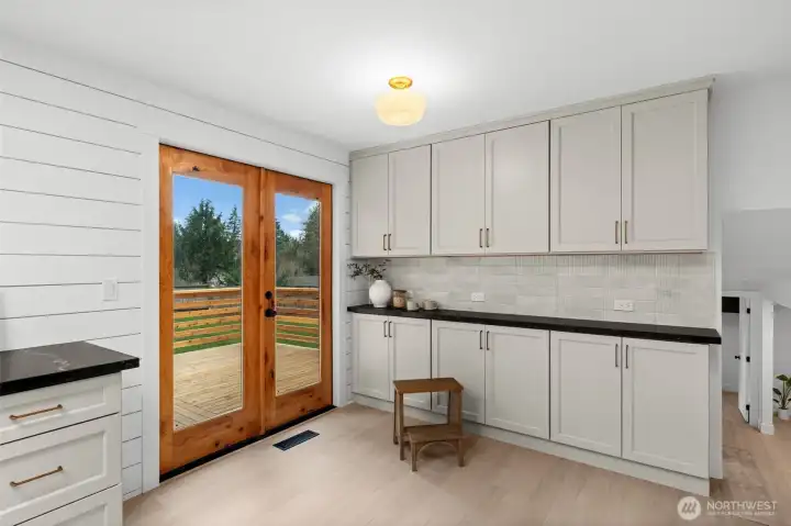 This high-capacity kitchen features a seamless transition to the expansive backyard deck, facilitating a sophisticated indoor-outdoor flow essential for large-scale residential hosting.