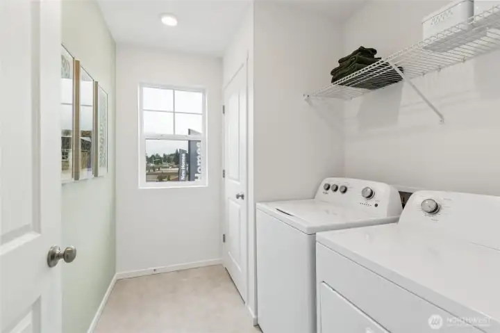 Dedicated laundry room with a window for natural light. Actual home is under construction and finishes, colors, and materials may vary. See site agent for details.