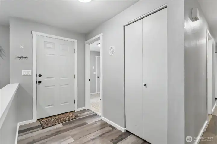 Entryway view, utility upper right, coat closet and then hallway. Love the flooring!